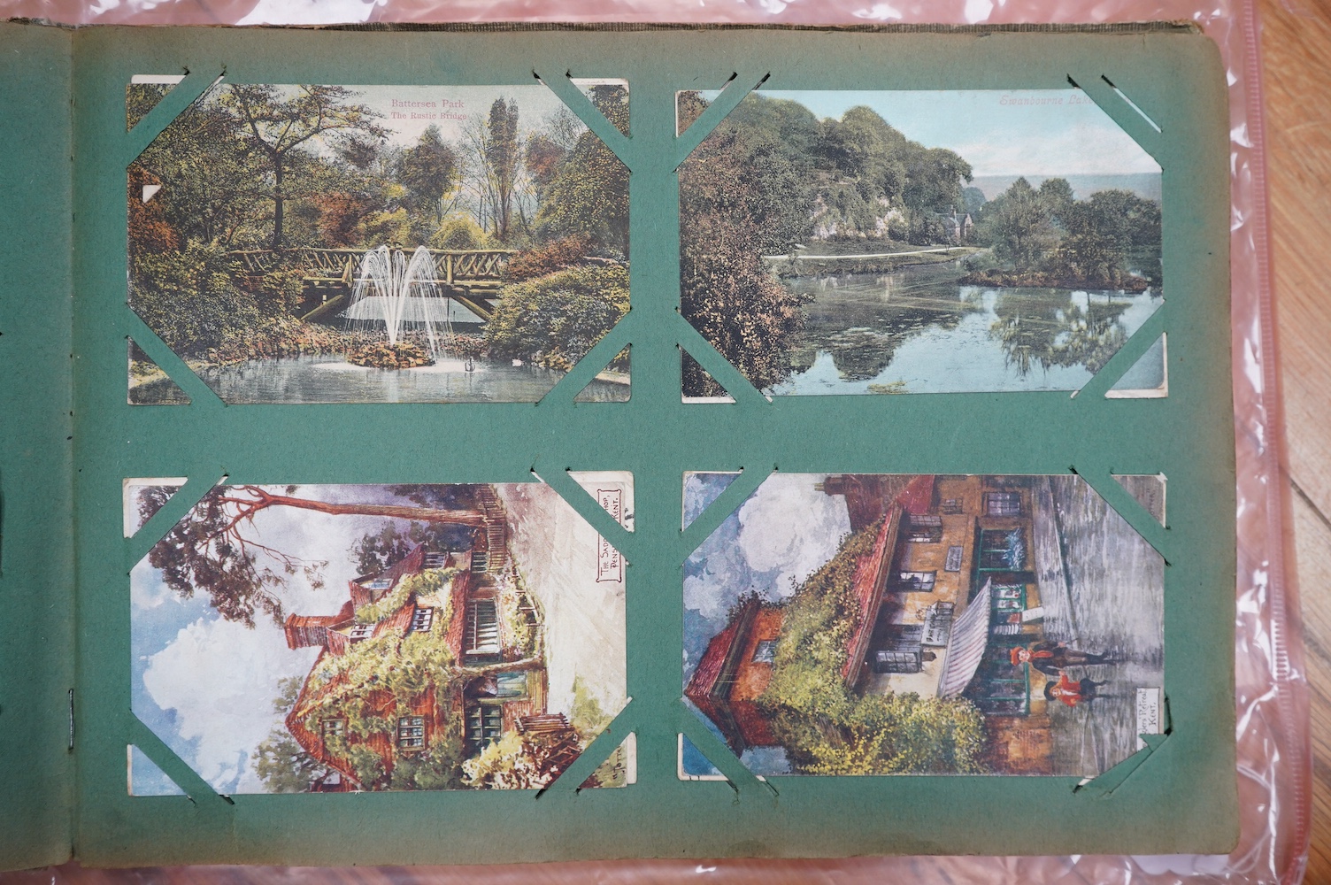 A postcard album with various postcards. Condition - damp damage